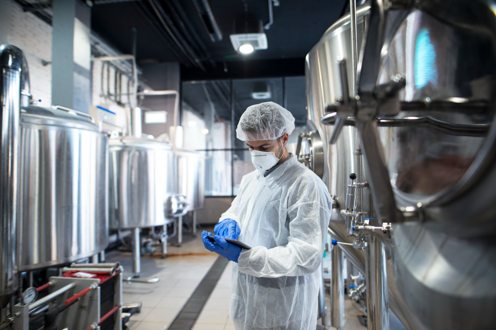 Technician in protective gear inspecting industrial tanks, representing Southern Cross Chemicals’ industrial chemical supply in Tulsa, Oklahoma.